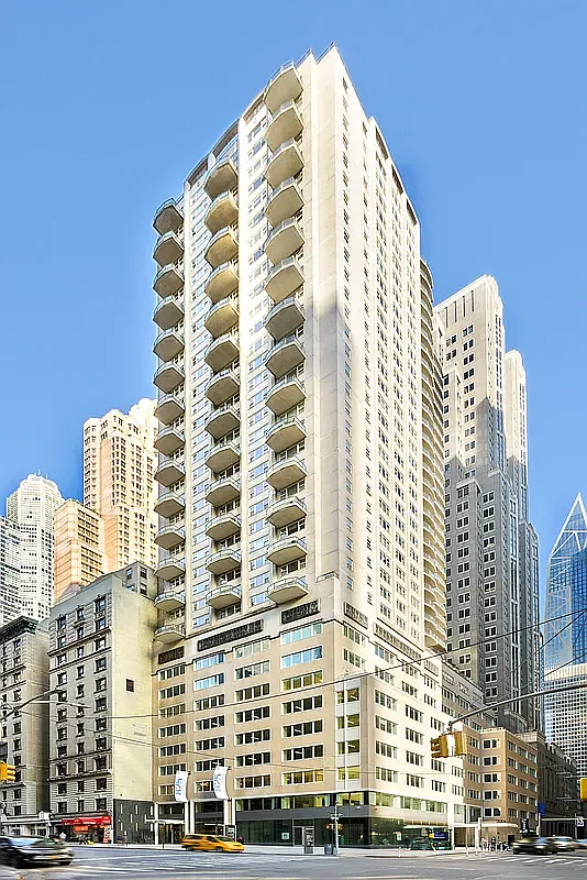Tower 53, a pale high-rise with stacked balconies, seen from the street on West 53rd Street